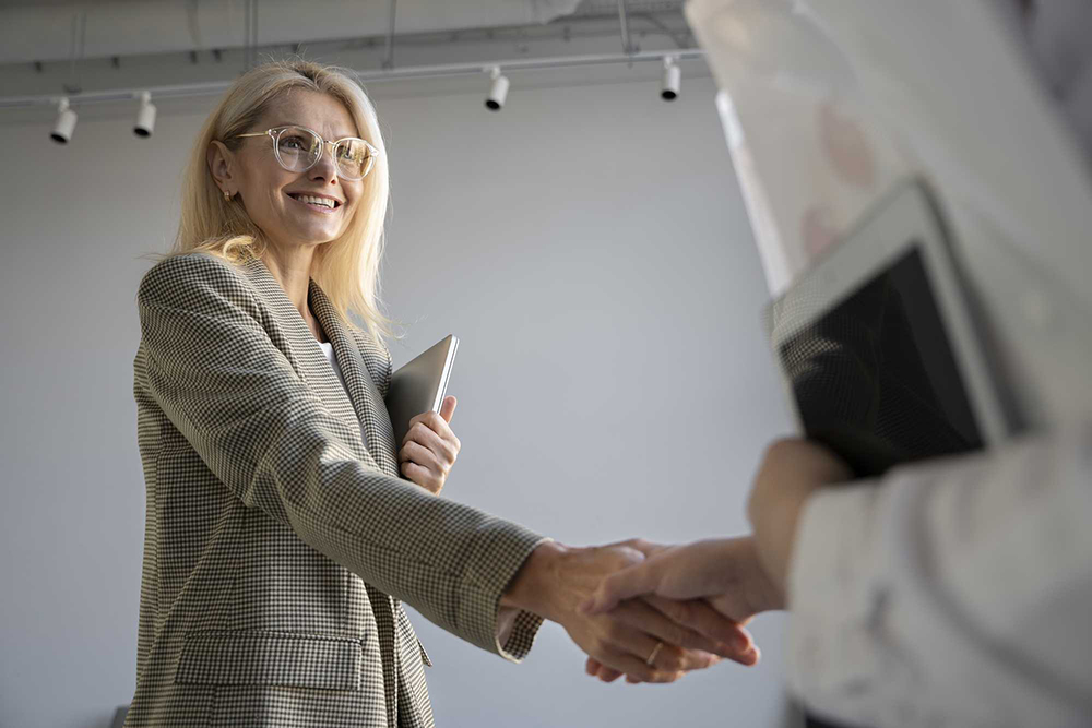 Mujer estrechando la mano al cliente