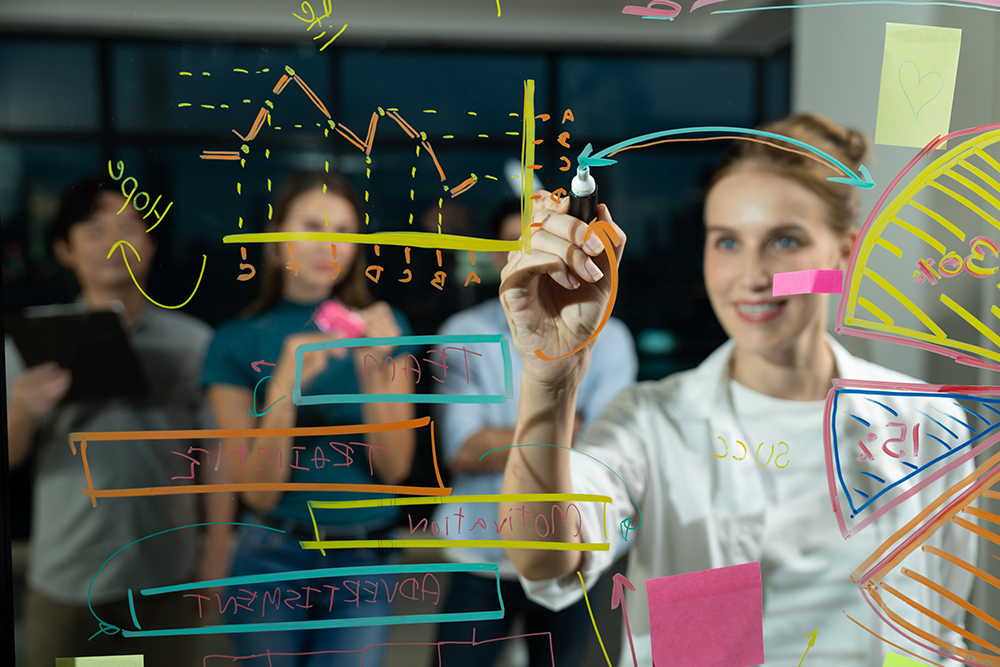 Mujer dibujando en pizarra estrategias de mercado